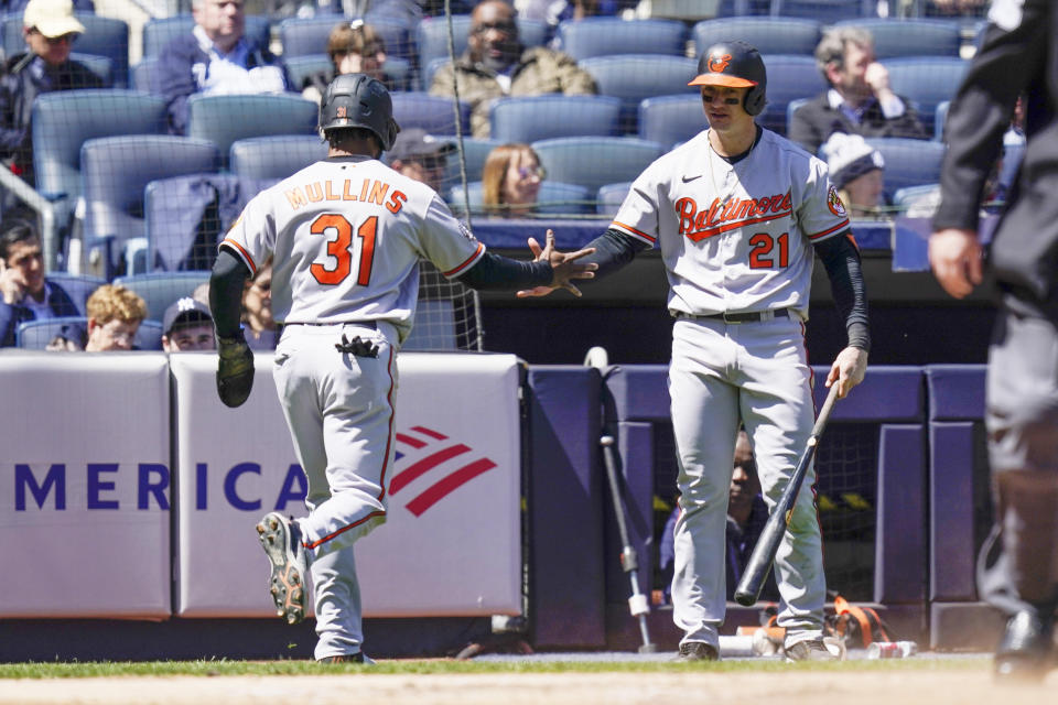 Baltimore Orioles' Cedric Mullins, left, is greeted by Austin Hays after Mullins scored on a ground-out hit by Trey Mancini during the third inning of a baseball game against the New York Yankees at Yankee Stadium, Thursday, April 28, 2022, in New York. (AP Photo/Seth Wenig)