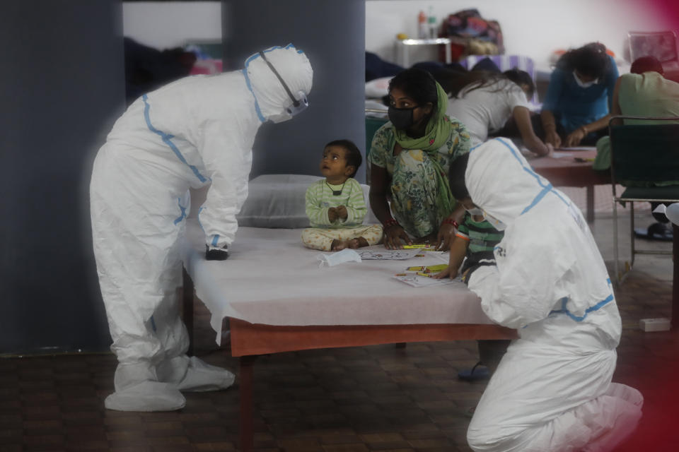 Doctors and health workers entertain children at a COVID-19 care center functioning in an indoor stadium in New Delhi, India, Monday, July 20, 2020. (AP Photo/Manish Swarup)