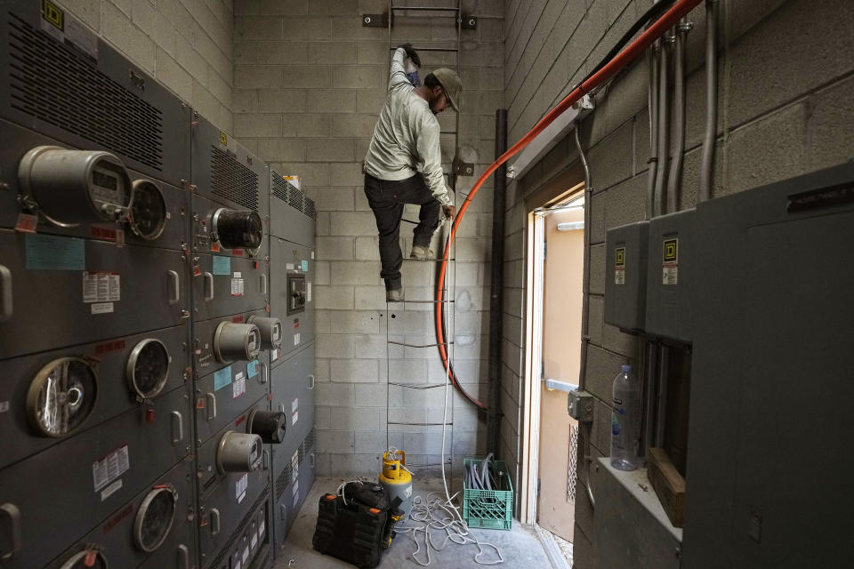 Michael Villa, a service tech at Total Refrigeration, works on a commercial air conditioning roof unit as temperatures are expected to hit 117-degrees, Wednesday, July 19, 2023, in Laveen, Ariz. (AP Photo/Ross D. Franklin)