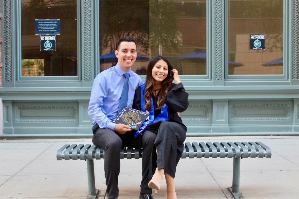 Viviana Vazquez wears a graduation gown as she sits with her fiancé Xavi on a bench