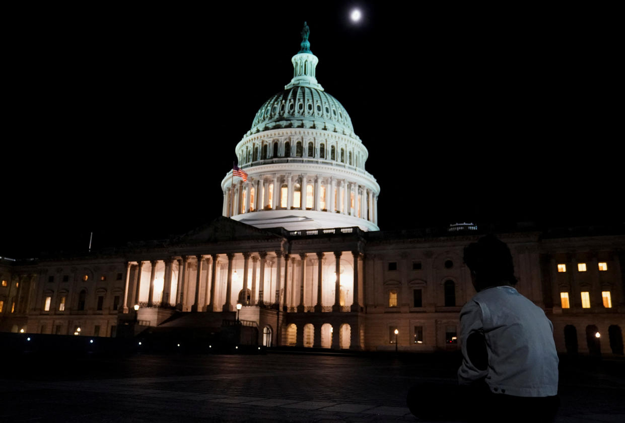 A person sits outside the U.S. Capitol after U.S. House Speaker Kevin McCarthy (R-CA) reached a tentative deal with President Joe Biden to raise the United States' debt ceiling and avoid a catastrophic default, in Washington, U.S. May 27, 2023. REUTERS/Nathan Howard