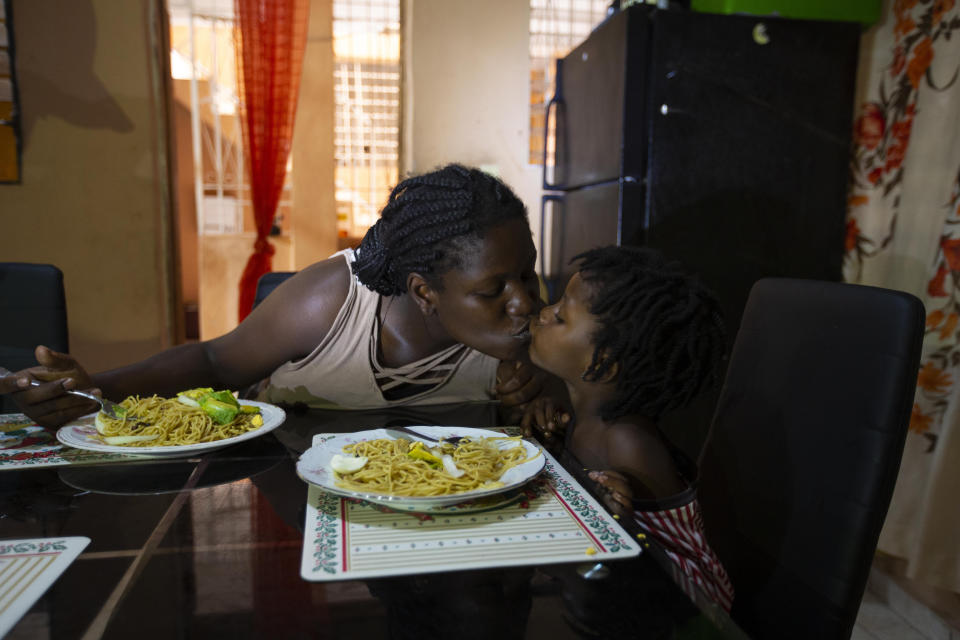 Deported from the United States a day before, Delta de Leon and her 2-year-old daughter Chloe share a kiss in their temporary home, in Port-au-Prince, Haiti, Thursday, Sept. 23, 2021. Breakfast on that first morning in Haiti consisted of spaghetti and bits of avocado. Normally, Chloe has milk and fruit, but de Leon said she was waiting on a money transfer to buy some basic food items. (AP Photo/Joseph Odelyn)
