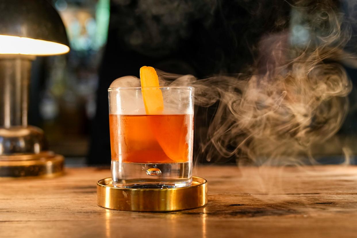 A “Smoke Signals” old fashioned by bartender Noah Rathnow at Buckeye Bourbon House is created with a private Maker’s Mark private select barrel bourbon and infused with hickory smoke.