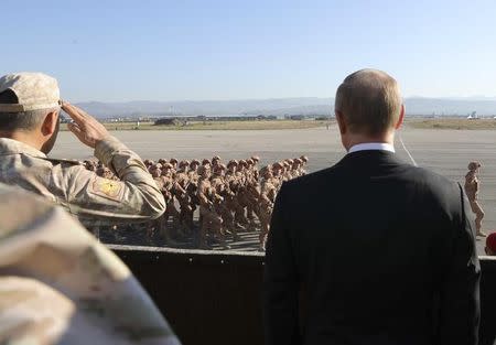 Russian President Vladimir Putin (R) and Defence Minister Sergei Shoigu watch servicemen passing by as they visit the Hmeymim air base in Latakia Province, Syria December 11, 2017. Sputnik/Mikhail Klimentyev/Sputnik via REUTERS