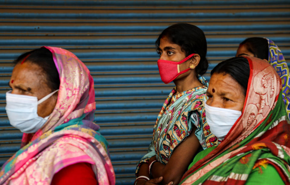 Voters stand in a queue to cast their votes outside a polling booth during first phase of elections in West Bengal state in Medinipur, India, Saturday, March 27, 2021. Voting began Saturday in two key Indian states with sizeable minority Muslim populations posing a tough test for Prime Minister Narendra Modi’s popularity amid a months-long farmers’ protest and the economy plunging with millions of people losing jobs because of the coronavirus pandemic. (AP Photo/Bikas Das)