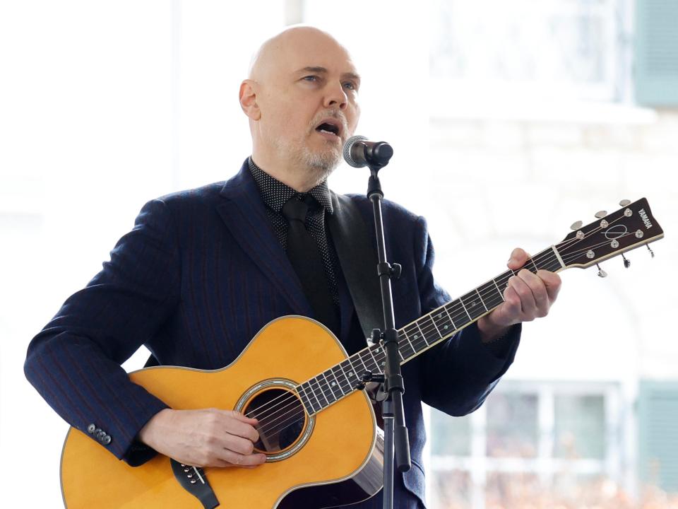 Billy Corgan, holding a guitar, performs onstage at the public memorial for Lisa Marie Presley.