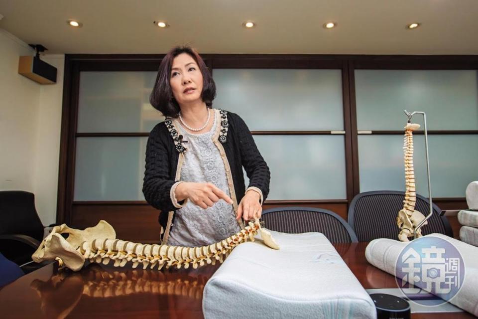譚芙芩利用人體脊椎模型，在裸枕上調整示範正確頸枕睡眠姿勢。