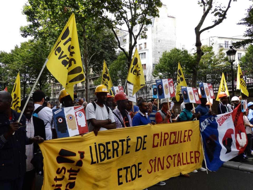 Protesters from the Droits Devant migrants' rights group at a Bastille Day march (Lizzie Dearden)