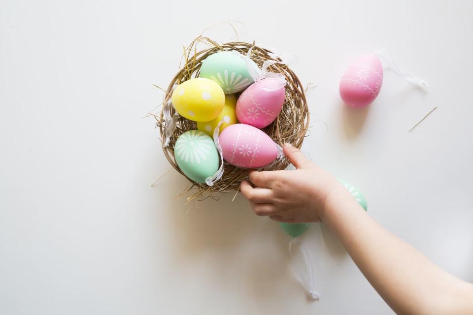 Easter Facts Hand Reaching for Colorful Eggs in Basket