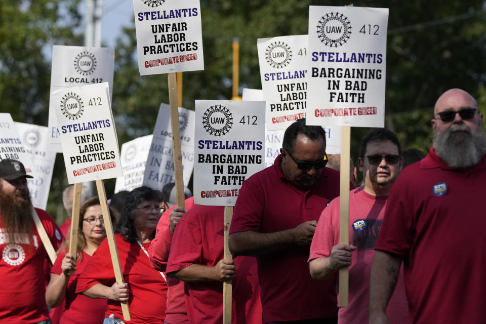 United Auto Workers march outside the Stellantis North American Headquarters, Wednesday, Sept. 20, 2023, in Auburn Hills, Mich. General Motors and Stellantis announced fresh layoffs Wednesday that they blamed on damage from the United Auto Workers strike, and the labor standoff grew more tense just two days before the union was expected to call for new walkouts. UAW President Shawn Fain said layoffs were unnecessary and an effort to pressure workers to settle for less in contract negotiations. (AP Photo/Carlos Osorio)