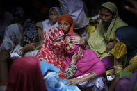 <p>A woman comforts the mother of Shakil, 38, an Indian man killed by a gang on early Thursday night, near Jewar, 80km (50miles) south Delhi, India, May 25, 2017. Police are searching for a gang of highway robbers who allegedly raped four women after dragging them into a field and fatally shooting Shakil who tried to save them. The six looted cash and valuables from the family and then raped the women, the victims alleged. Violent crimes against women have been on the rise in India despite tough laws enacted by the government. (Photo: Altaf Qadri/AP) </p>