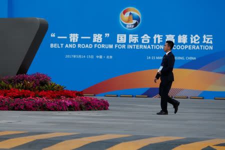 A man walks past the China National Convention Center, a venue of the upcoming Belt and Road Forum in Beijing, China, May 12, 2017. REUTERS/Thomas Peter