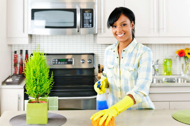 C17B2T Smiling young black woman with sponge and rubber gloves cleaning kitchen spring cleaning woman; cleaning; smiling; kitche