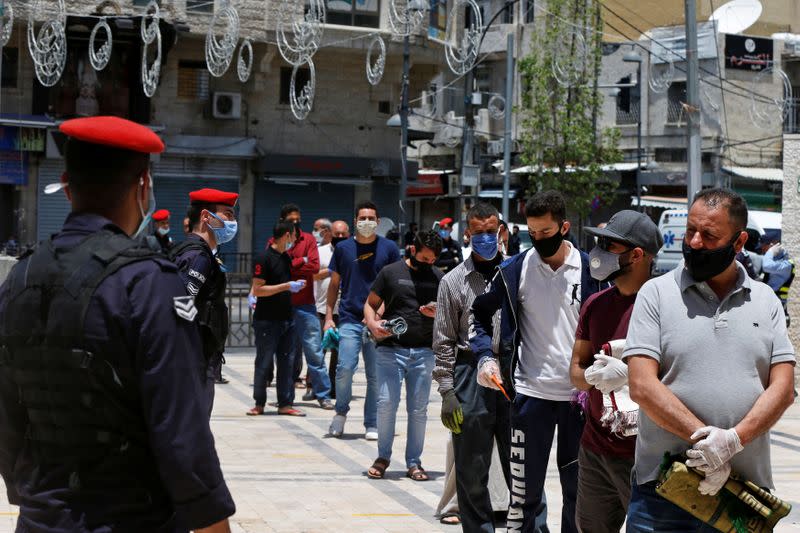 Muslims stand in line before taking part in Friday prayers at al Husseini mosque in Amman