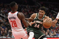 Milwaukee Bucks forward Giannis Antetokounmpo (34) fouls Washington Wizards center Ian Mahinmi (28) during the first half of an NBA basketball game, Monday, Feb. 24, 2020, in Washington. (AP Photo/Nick Wass)