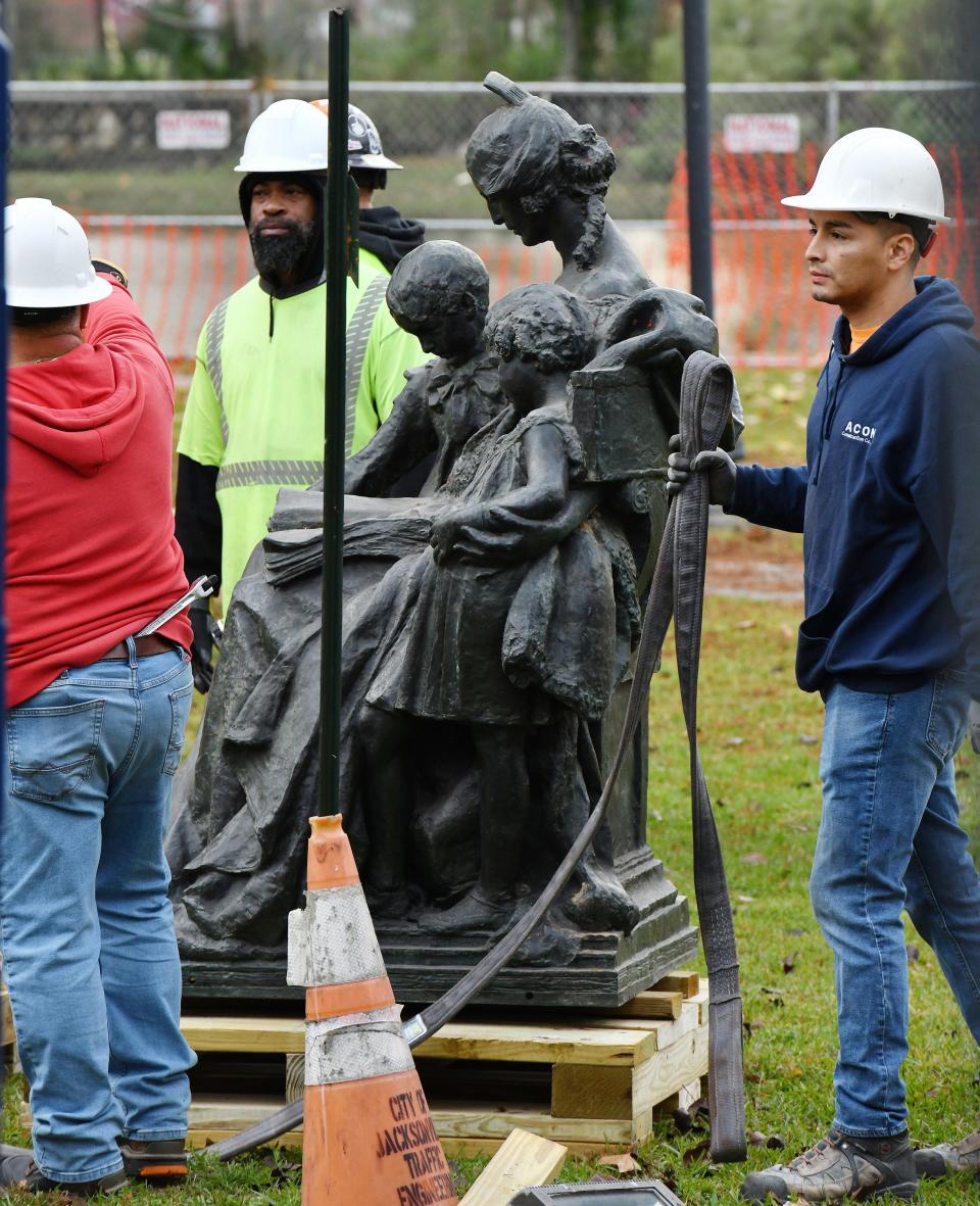 The bronze statue of a woman reading to two children is placed on pallets after being removed from the "Women of the Southland" monument on Dec. 27. Crews began the process of removing the Confederate statues from the "Women of the Southland" monument in Jacksonville's Springfield Park early in the morning after years of debate about the fate of the pro confederate structure.