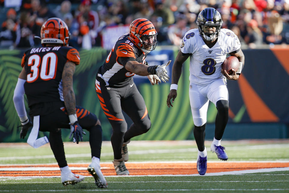 Baltimore Ravens quarterback Lamar Jackson (8) runs the ball for a touchdown against Cincinnati Bengals defensive end Carlos Dunlap (96) during the second half of NFL football game, Sunday, Nov. 10, 2019, in Cincinnati. (AP Photo/Frank Victores)