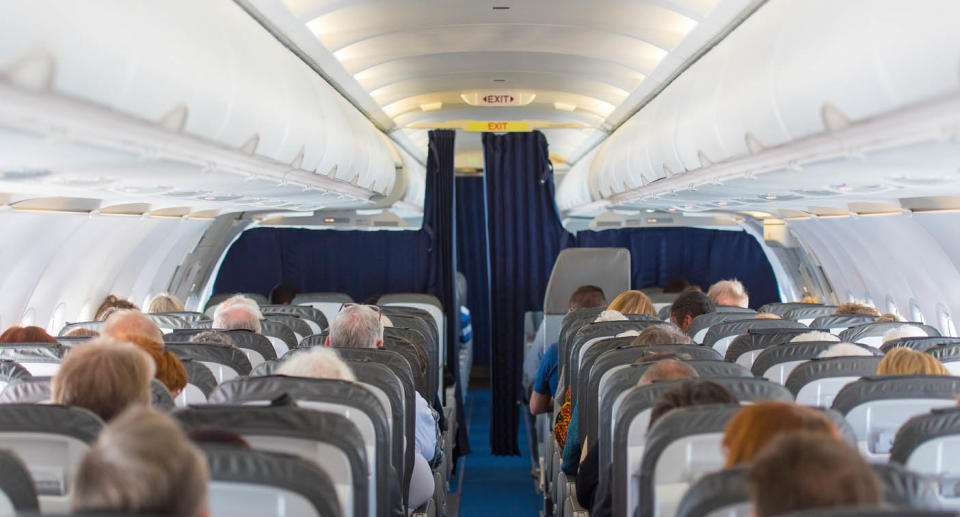 A generic photo of the inside of a plane with passengers.