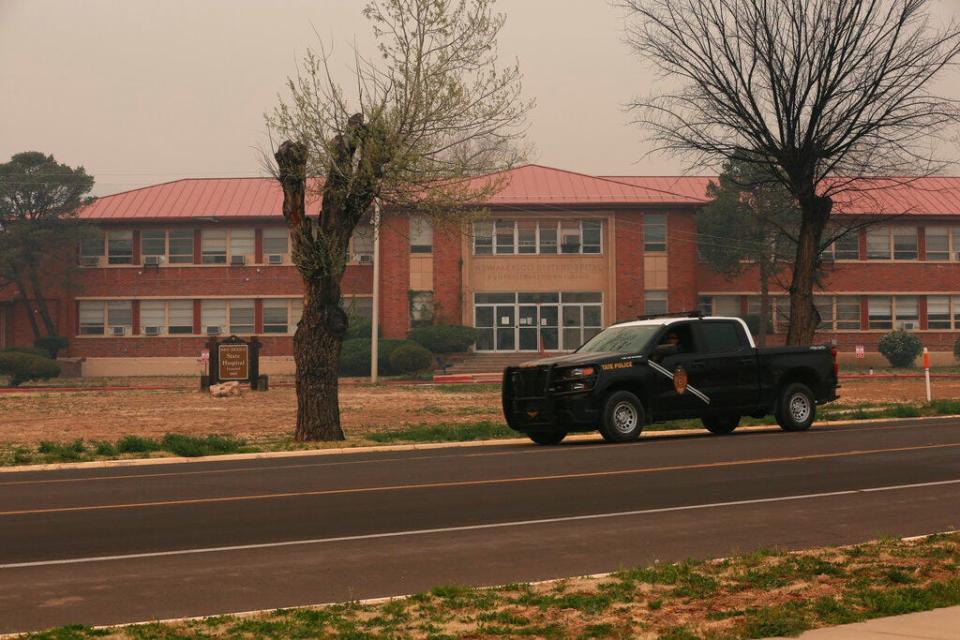 A New Mexico State Police vehicle drives by the New Mexico State Hospital in Las Vegas, N.M., a mental care facility, which was evacuated, Monday, May 2, 2022.