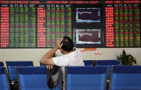 An investor sits in front of an electronic board showing stock information at brokerage house in Fuyang, Anhui province, China, October 14, 2015. REUTERS/China Daily CHINA OUT