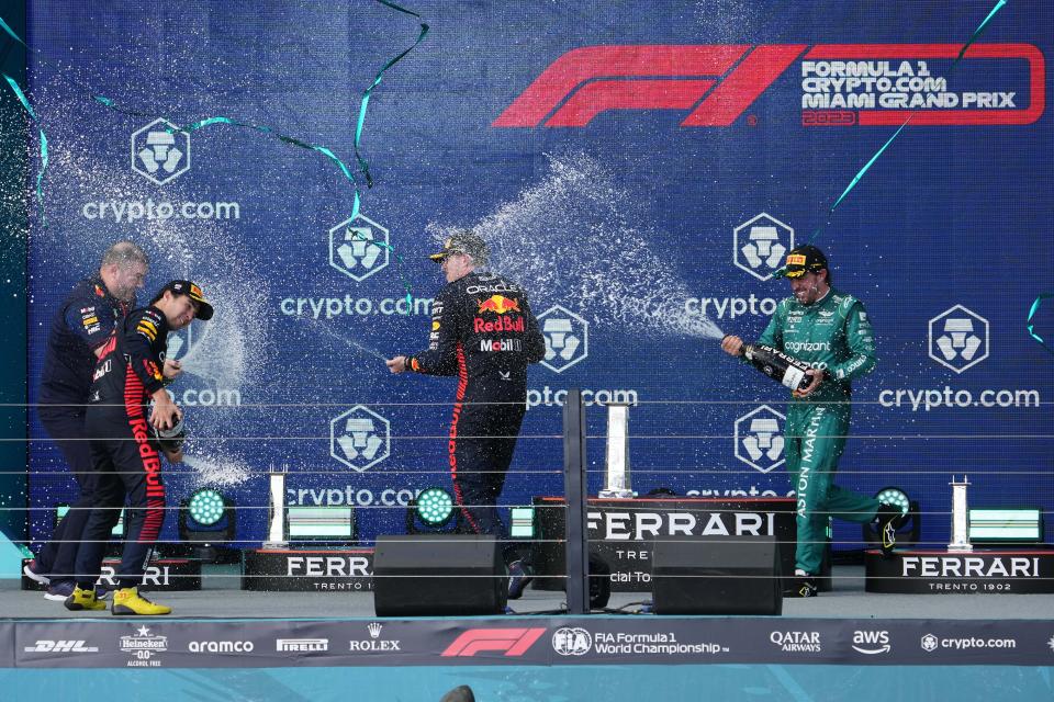 May 7, 2023; Miami Gardens, Florida, USA; Red Bull driver Max Verstappen (1) of the Netherlands, Red Bull driver Sergio Perez (11) of Mexico and Aston Martin driver Fernando Alonso (14) of Spain celebrate thier podium finishes by spraying champagne after the Miami Grand Prix at Miami International Autodrome. Mandatory Credit: Jasen Vinlove-USA TODAY Sports