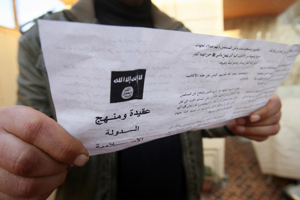 A man reads a pamphlet issued by al-Qaida-linked militants in Fallujah, Iraq, Thursday, Jan. 16, 2014. Members of al-Qaida's local franchise handed out pamphlets urging residents in the western city of Fallujah to take up arms and back the militants in their weeks-long fight against Iraqi troops as clashes raged on around the city, residents said Thursday. (AP Photo)