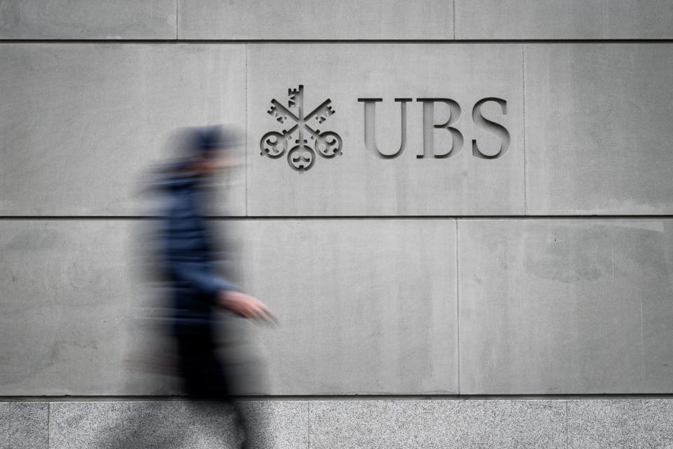 A pedestrian walks by the logo of Swiss banking giant UBS engraved on the wall of its headquarters on May 8, 2019 in Zurich. (Photo by Fabrice COFFRINI / AFP)        (Photo credit should read FABRICE COFFRINI/AFP/Getty Images)