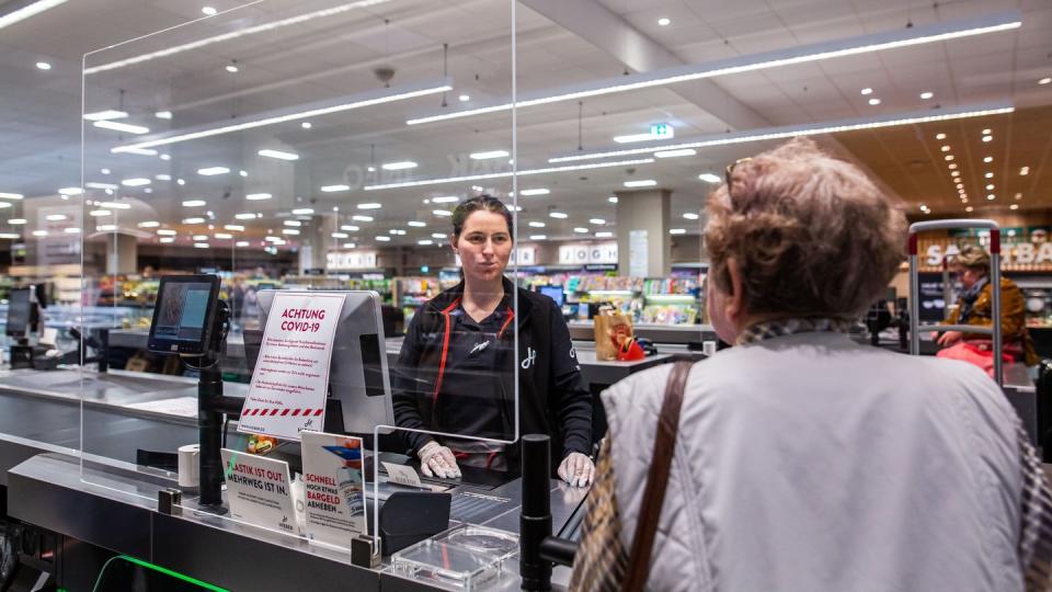 In einem Supermarkt in Rheinfelden in Baden-Württemberg wird die Kassiererin von einer Plexiglasscheibe geschützt.