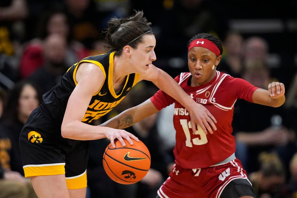 Iowa guard Caitlin Clark (22) drives past Wisconsin guard Ronnie Porter (13) during the first half of an NCAA college basketball game, Tuesday, Jan. 16, 2024, in Iowa City, Iowa. (AP Photo/Charlie Neibergall)