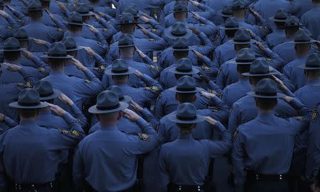 Pennsylvania State Police salute as they line the streets outside St. Peters' Cathedral in Scranton, Pennsylvania September 18, 2014, as the casket carrying slain Pennsylvania State Police Trooper Corporal Bryon Dickson, 38, is carried into the cathedral for his funeral service. REUTERS/Mike Segar