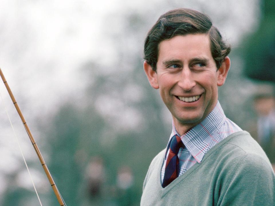 King Charles smiles and holds a fishing rod in 1979