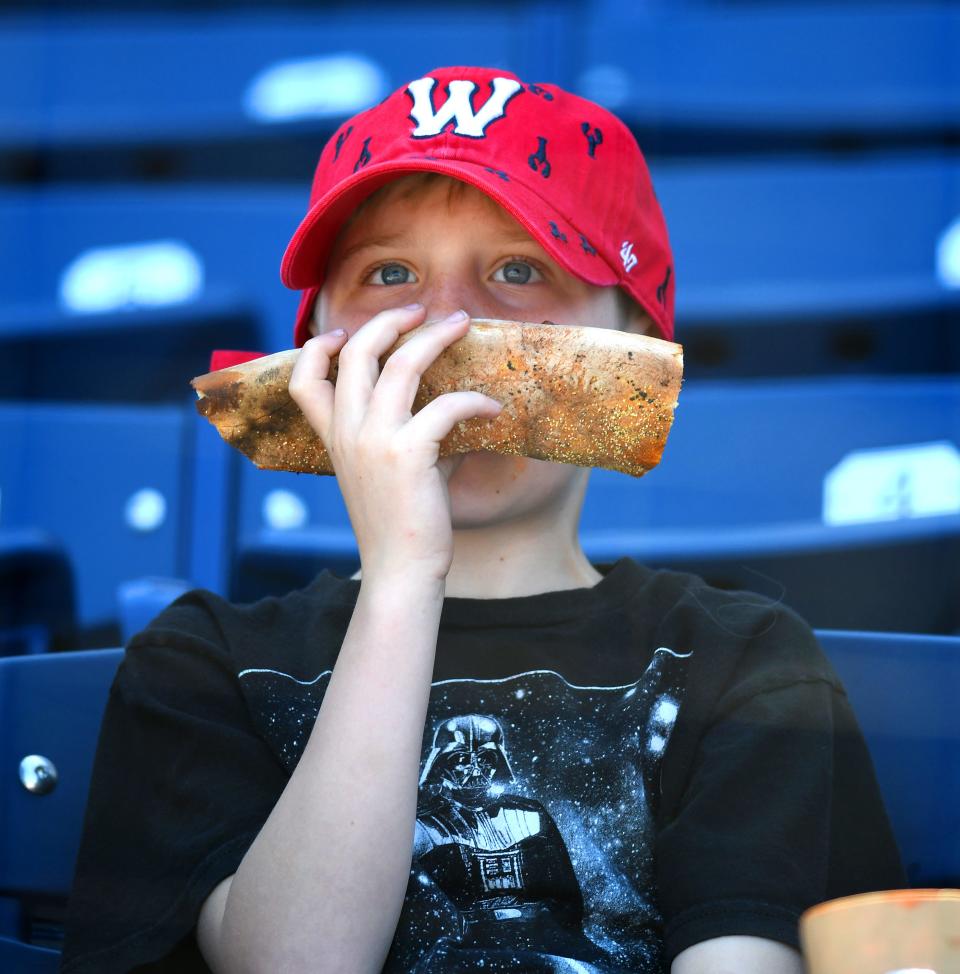 A young fan munches on what appears to be pizza during the Worcester Red Sox game.