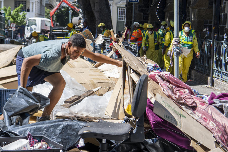 A man gathers his belongings, outside the Central Methodist Mission Church in Cape Town, South Africa, Sunday, March 1, 2020 as city officials and police move in to evict people. Hundreds of migrants have been removed from central Cape Town by South African authorities following a months-long stand-off. The migrants removed on Sunday had demanded to be relocated to other countries claiming they had been threatened by xenophobic violence last year. (AP Photo)