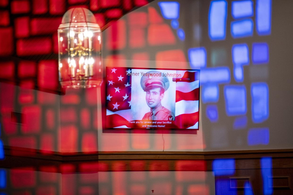 Sgt. Turner Yearwood Johnston's image is shown in the reflection of stained glass at the chapel at Dossman Funeral home in Belton.