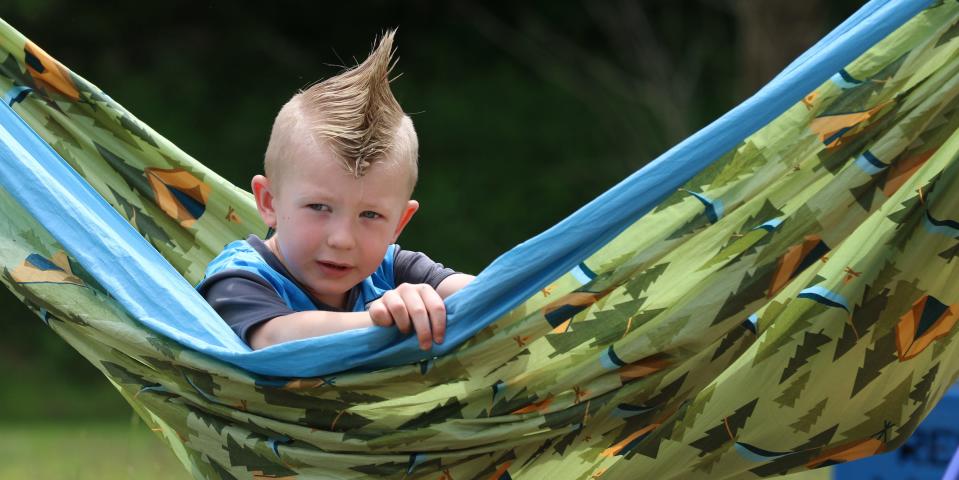 Four-year-old Wyatt Slininger tries out a hammock at the REI booth during the Goat Island Games held Saturday, May 7, 2022, in Cramerton.