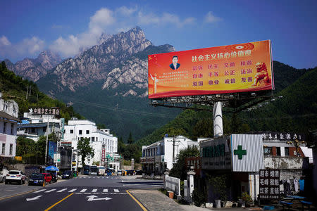 A poster with a portrait of Chinese President Xi Jinping overlooks a street in Huangshan, Anhui province, China, September 16, 2017. The slogan reads: "Core Socialist Values: prosperity, democracy, civility, and harmony; freedom, equality, justice, rule of law; patriotism, dedication, integrity and friendship." Picture taken September 16, 2017. REUTERS/Aly Song