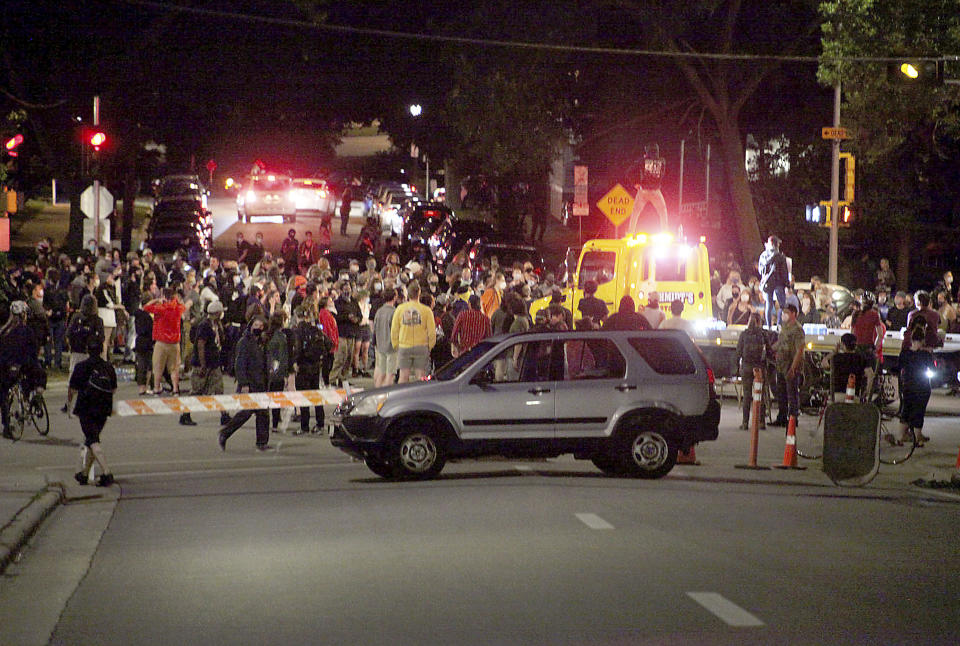 Protesters block traffic at an intersection an intersection near Capitol Square in Madison, Wis. Tuesday, June 23, 2020. Crowds outside the Wisconsin State Capitol tore down two statues and attacked a state senator amid protests following the arrest of a Black man who shouted at restaurant customers through a megaphone while carrying a baseball bat. (Emily Hamer/Wisconsin State Journal via AP)