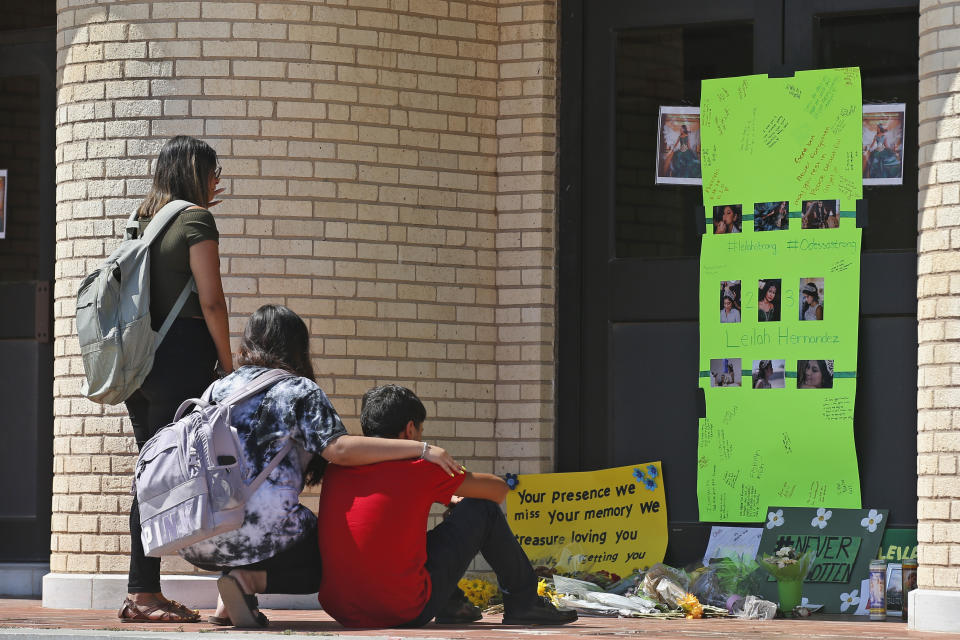People gather at a memorial to slain high school student Leilah Hernandez, Tuesday, Sept. 3, 2019, at Odessa High School in Odessa, Texas. Hernandez was a victim of Saturday's shooting rampage. (AP Photo/Sue Ogrocki)