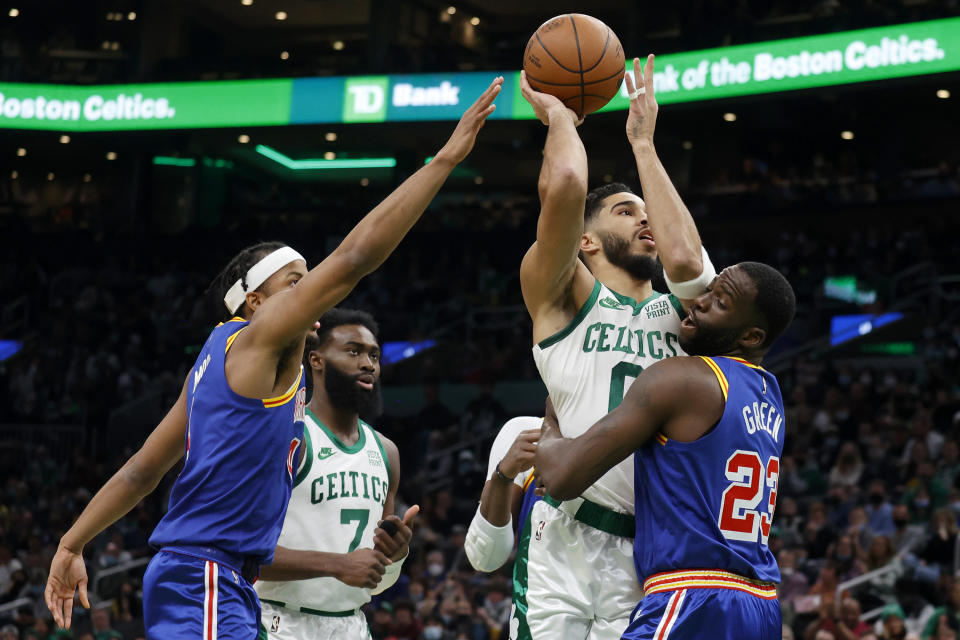 Boston Celtics forward Jayson Tatum (0) drives to the basket as Golden State Warriors forward Draymond Green (23) and guard Moses Moody, left, defend during the first half of an NBA basketball game, Friday, Dec. 17, 2021, in Boston. (AP Photo/Mary Schwalm)
