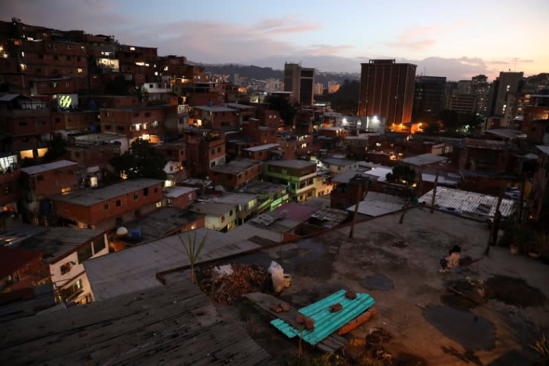 A child watches a movie projected on a giant screen, from her house's roof in the low-income neighborhood of Petare, amid the coronavirus disease (COVID-19) outbreak in Caracas