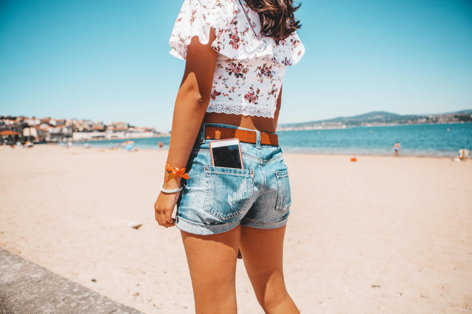 woman  in jeans shorts with the phone in pocket