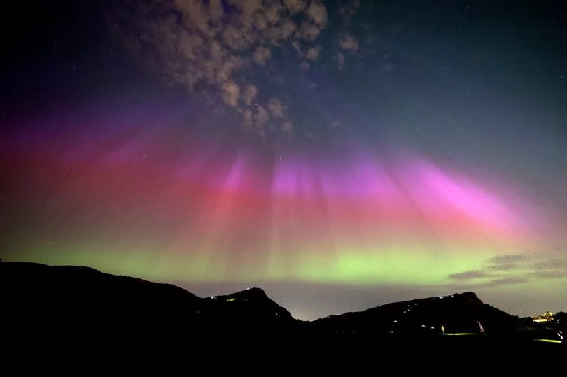 The aurora borealis, also known as the northern lights, above Arthurs Seat and Salisbury Crags in Holyrood Park, Edinburgh