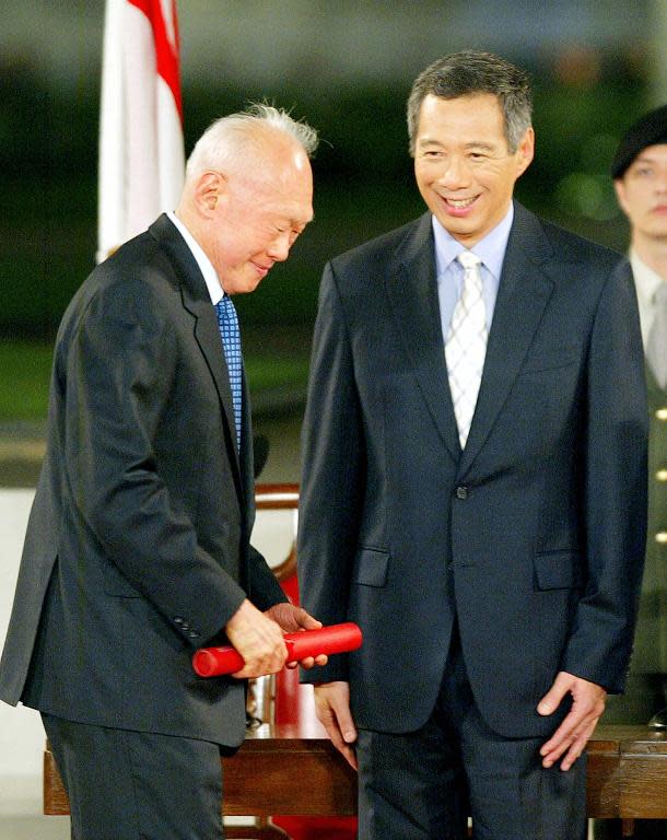 Then newly-installed Prime Minister Lee Hsien Loong (R) with his father Lee Kuan Yew at the oath-taking ceremony in Singapore on August 12, 2004