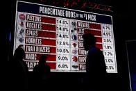 People look at the draft lottery order during the NBA basketball draft lottery in Chicago, Tuesday, May 16, 2023. (AP Photo/Nam Y. Huh)