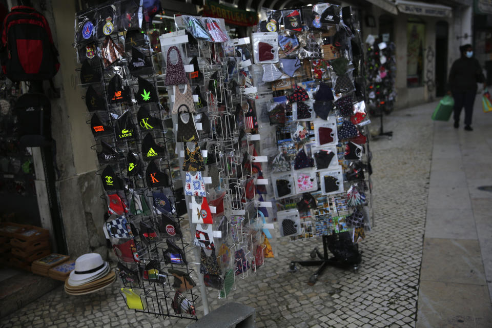 Postcard racks are filled instead with face masks outside souvenir shops in Lisbon's old center, Wednesday, Dec. 2, 2020. (AP Photo/Armando Franca)