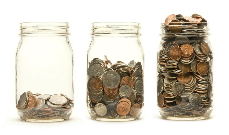 Three change jars filled with an increasing number of coins.