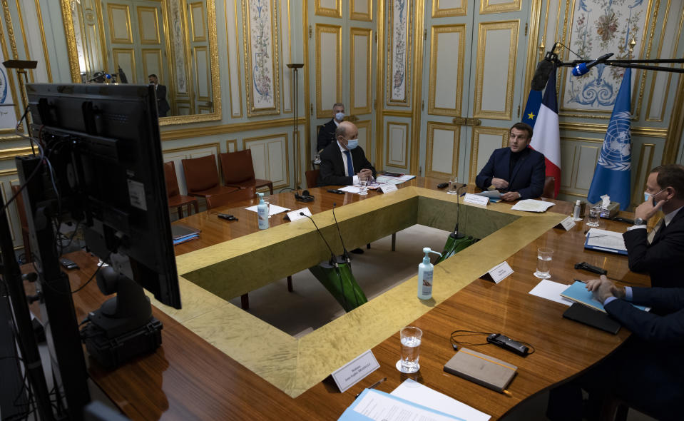 French President Emmanuel Macron, right, makes introductory remarks during a visio-conference meeting about support and aid for Lebanon, at the Elysee Palace in Paris, France, Wednesday, Dec. 2, 2020. France is hosting an international video conference on humanitarian aid for Lebanon amid political deadlock in Beirut that has blocked billions of dollars in assistance for the cash-strapped country. (Ian Langsdon, Pool via AP)