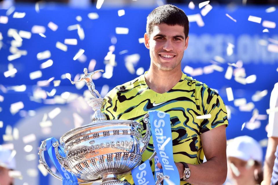 Carlos Alcaraz smiles as he holds the trophy after beating Greece's Stefanos Tsitsipas during the ATP Barcelona Open, 2023 (AFP via Getty Images)