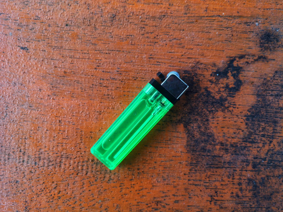 A green lighter on a wooden table