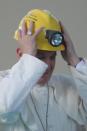 Pope Francis wore a hard hat he received from a miner during a mass outside the Shrine of Our Lady of Bonaria in Cagliari September 22, 2013. REUTERS/Osservatore Romano